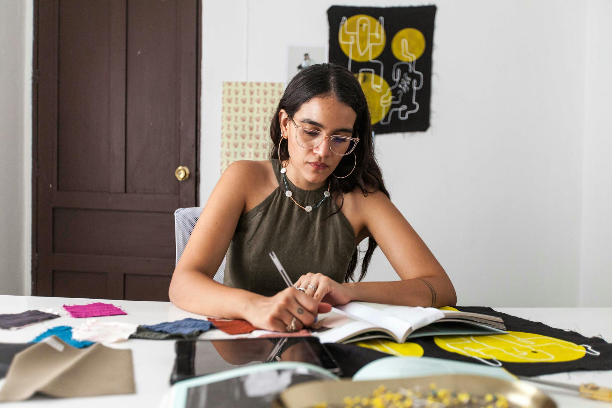 Young female fashion designer sketching ideas at her workspace.